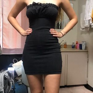 A form-fitting strapless black jean material dress